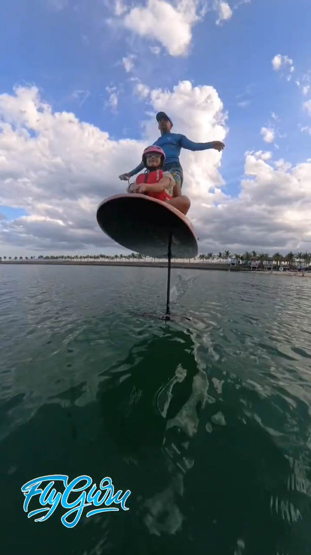 Tandem eFoil ride: instructor and child gliding above water